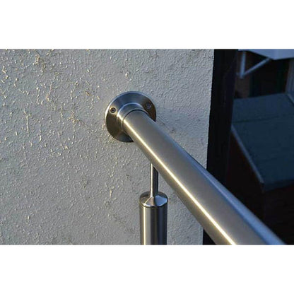 Handrail wall connector installed against masonry